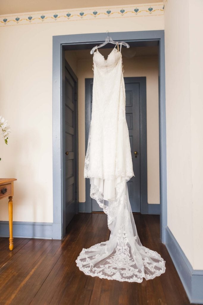 A wedding dress hangs in a room with exquisite details.