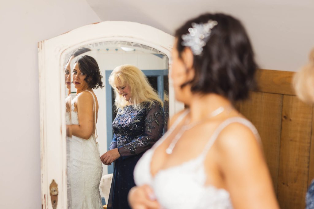 A bride is preparing for her wedding in front of a mirror.