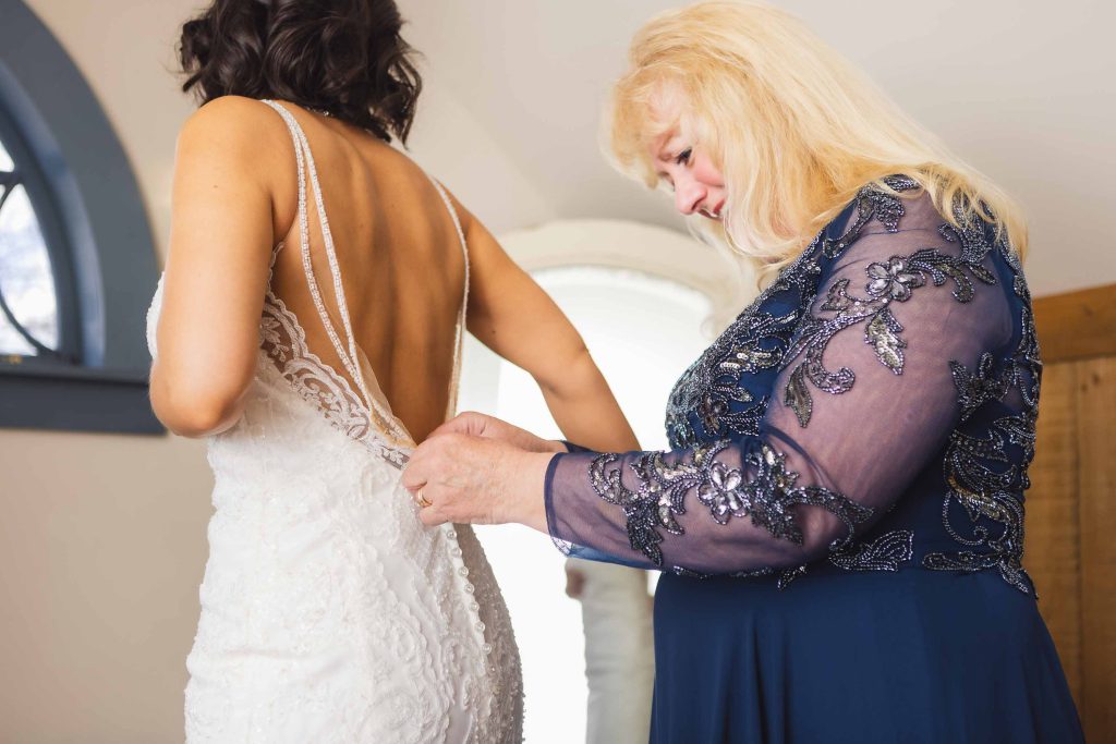 A woman is helping her mother prepare for her wedding.