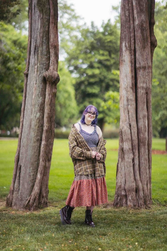 A high school senior posing for a portrait in a park.