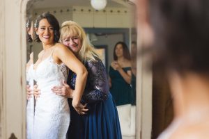 A bride embraces her mother in candid preparation for the wedding.