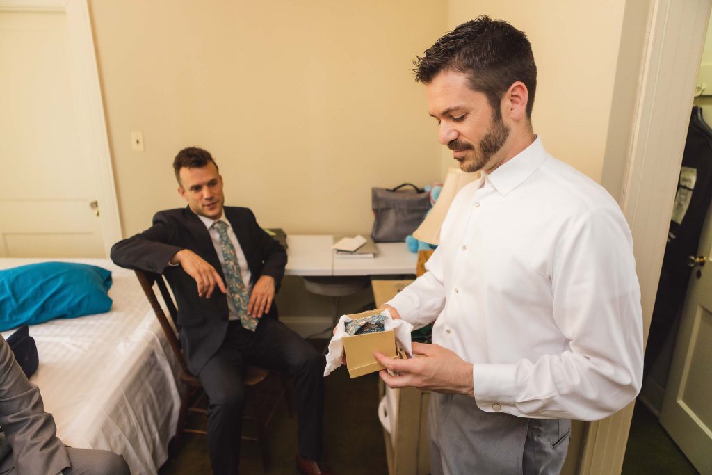 A man in a suit is candidly preparing for a wedding.
