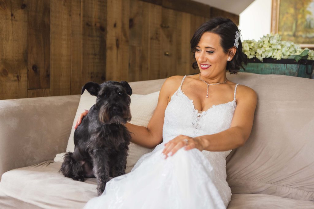 A portrait of a bride with her dog during her wedding.