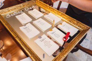 Wedding seating chart in a gold frame suitable for candid preparation.