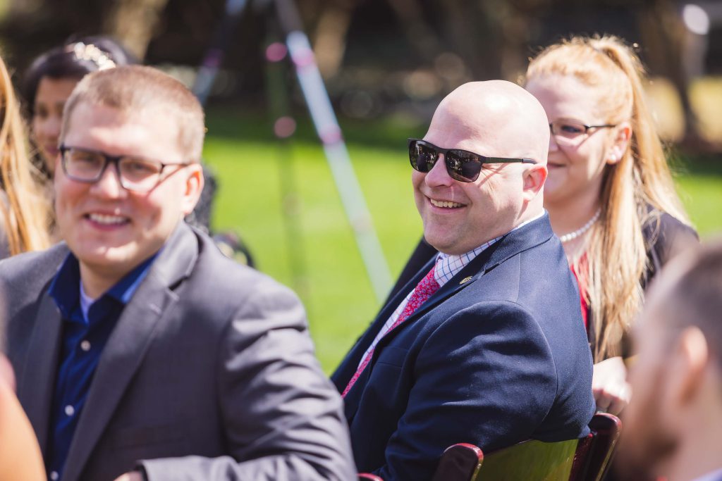 A group of people smiling at a wedding ceremony.