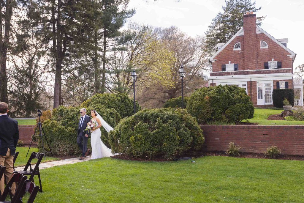 A wedding ceremony with a bride and groom standing in front of a brick house.