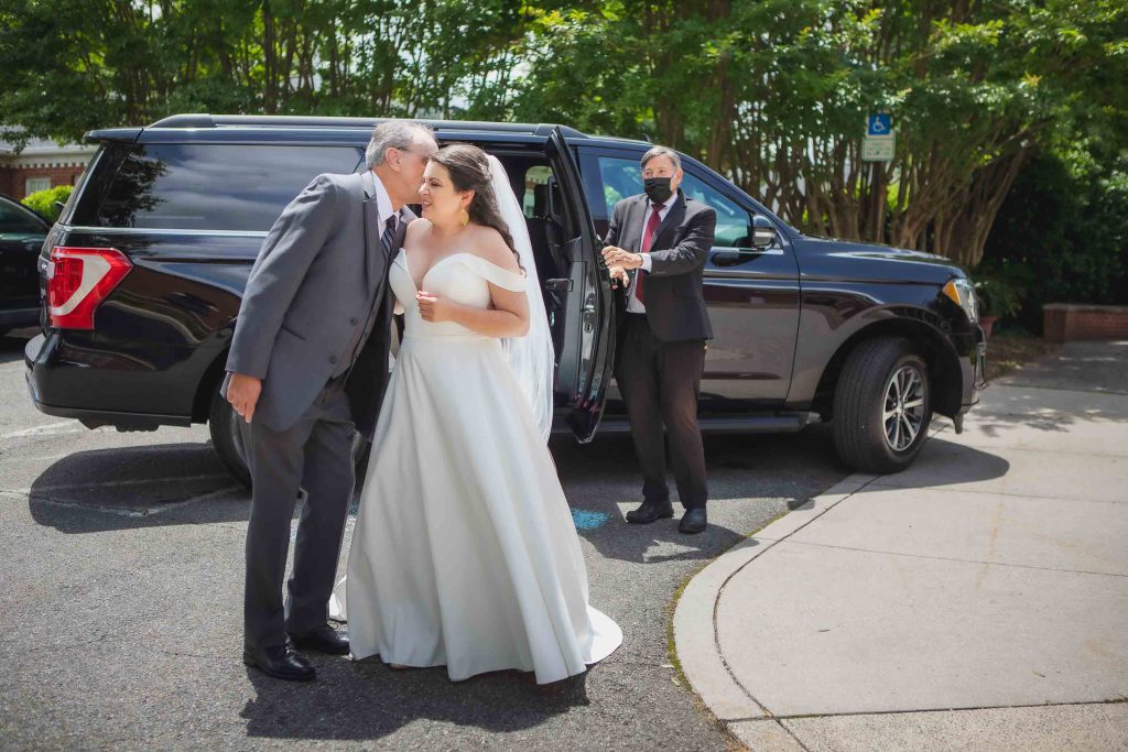 A candid bride and groom kissing during wedding preparation.