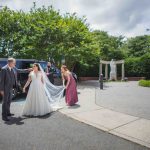 A candid bride and groom walking to their car in front of a church after the wedding preparations.
