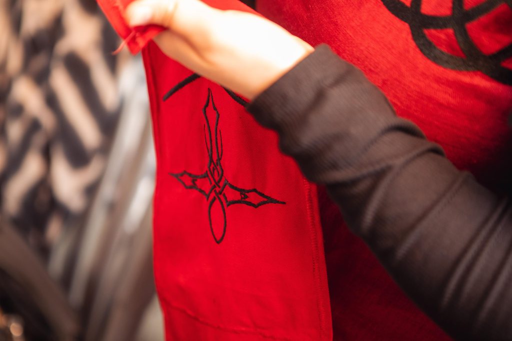 A woman wearing a red apron preparing for a wedding.
