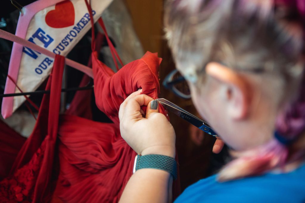 A bride prepares her candid wedding dress for hanging.