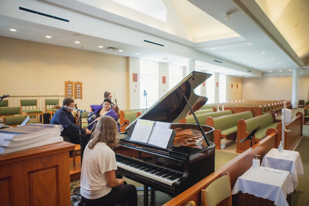 A group of people preparing for a candid wedding in a church.
