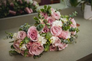 A bouquet of pink and white roses adds delicate details to a wedding.