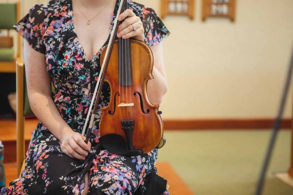 A woman playing a violin during a wedding ceremony.