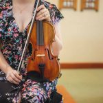 A woman playing a violin during a wedding ceremony.