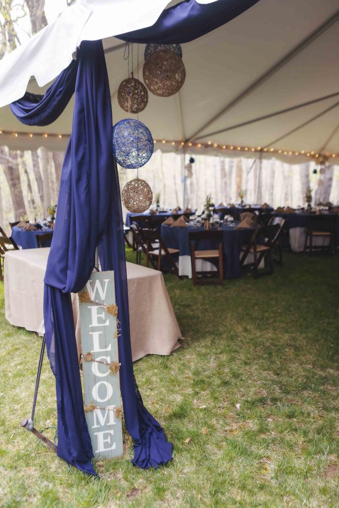 A detailed blue tent with a welcome sign for a wedding.