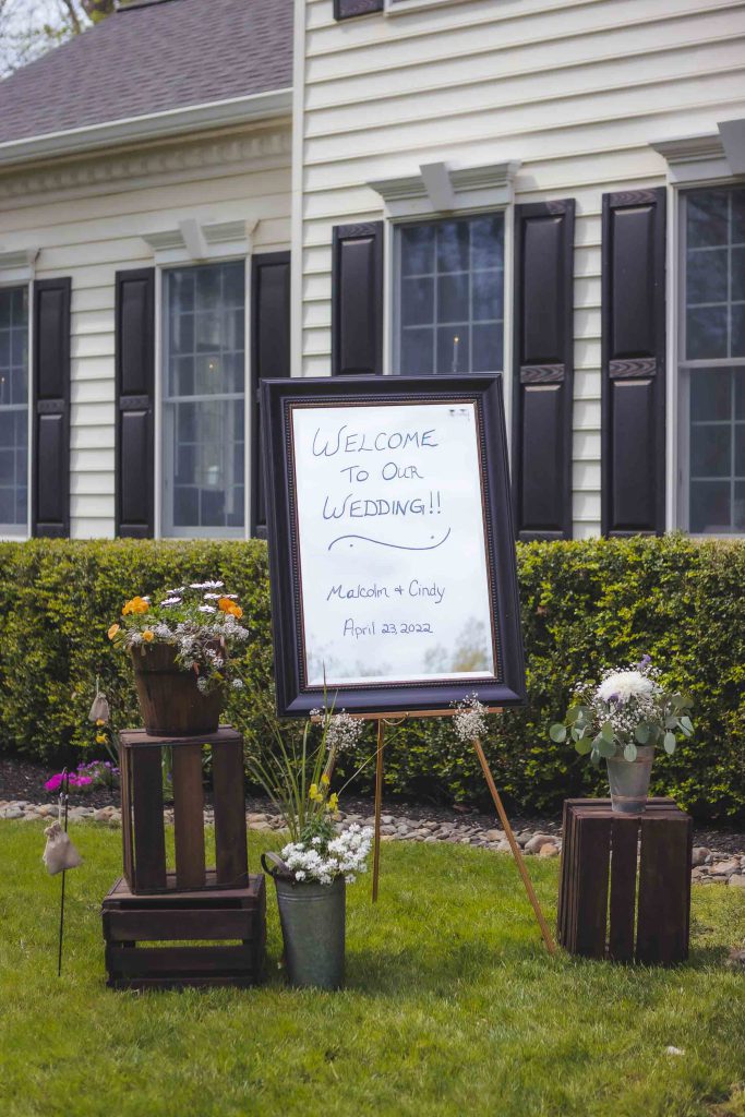 A detailed wedding sign in front of a house.