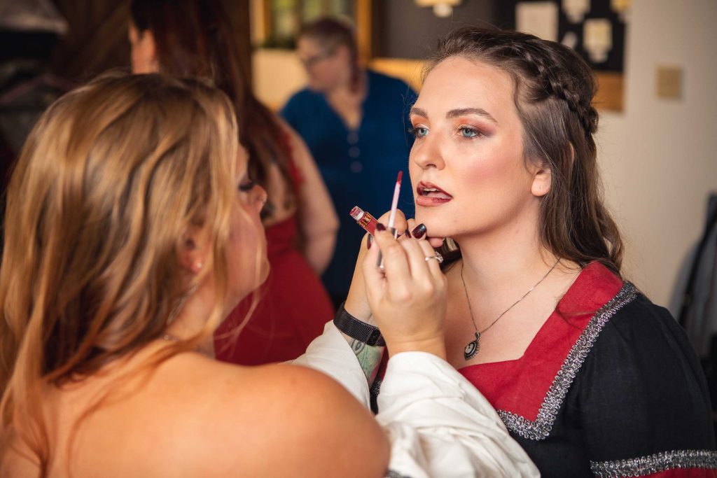 A candid woman preparing for a wedding with makeup.