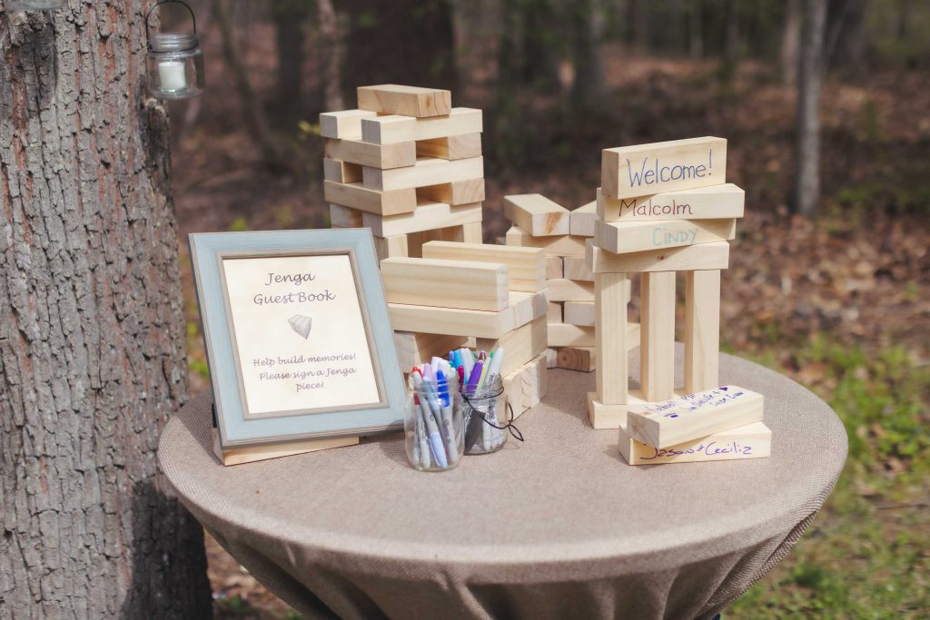 A wedding table with wooden blocks and pens on it.