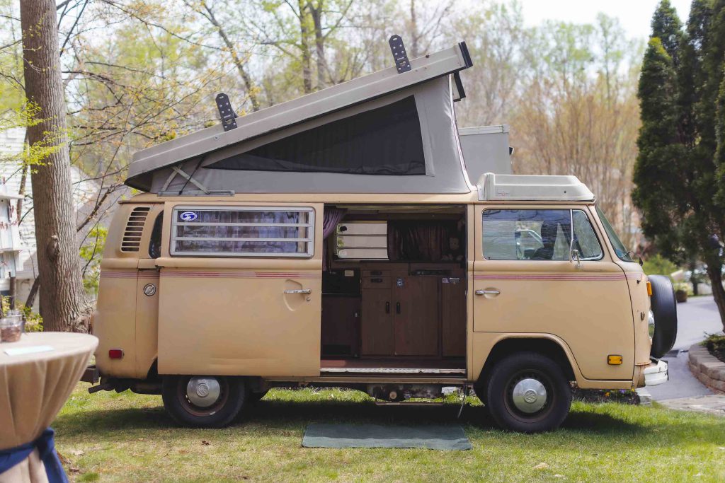 A vw bus parked in a yard with attention to wedding details.