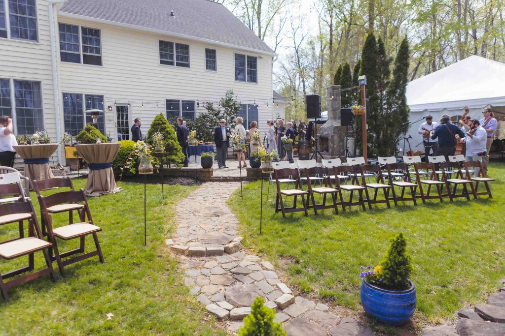 A detailed wedding ceremony setup in a house yard.