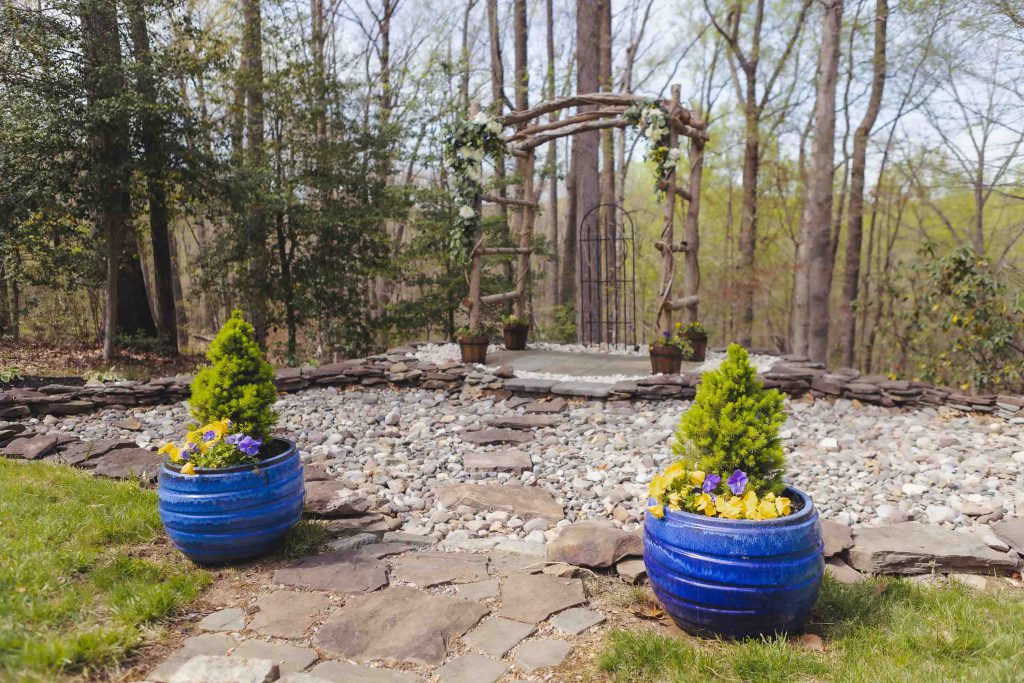 Two blue potted plants in a wooded area with details.