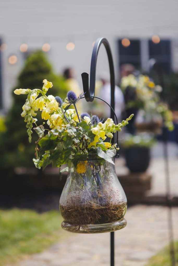 A wedding arrangement of flowers in a glass vase with intricate details.