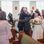 A bride and groom embracing in a church during their wedding ceremony.