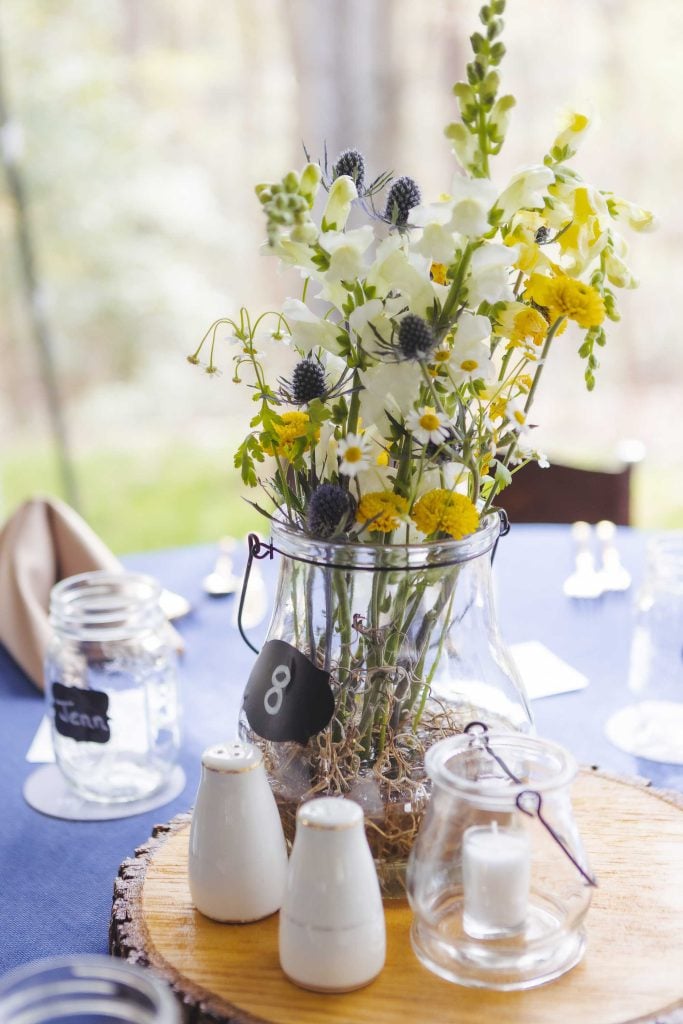 An arrangement of flowers in a glass vase on a wedding table.