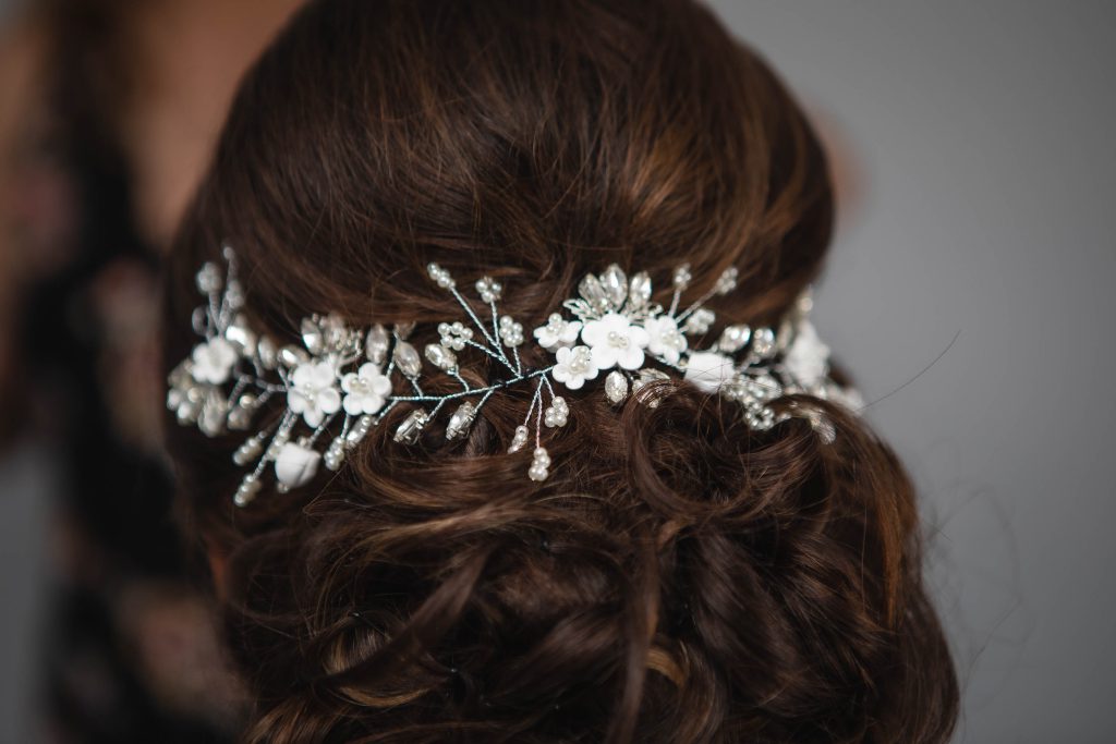 A bride with a flower hair comb in her hair on her wedding day.