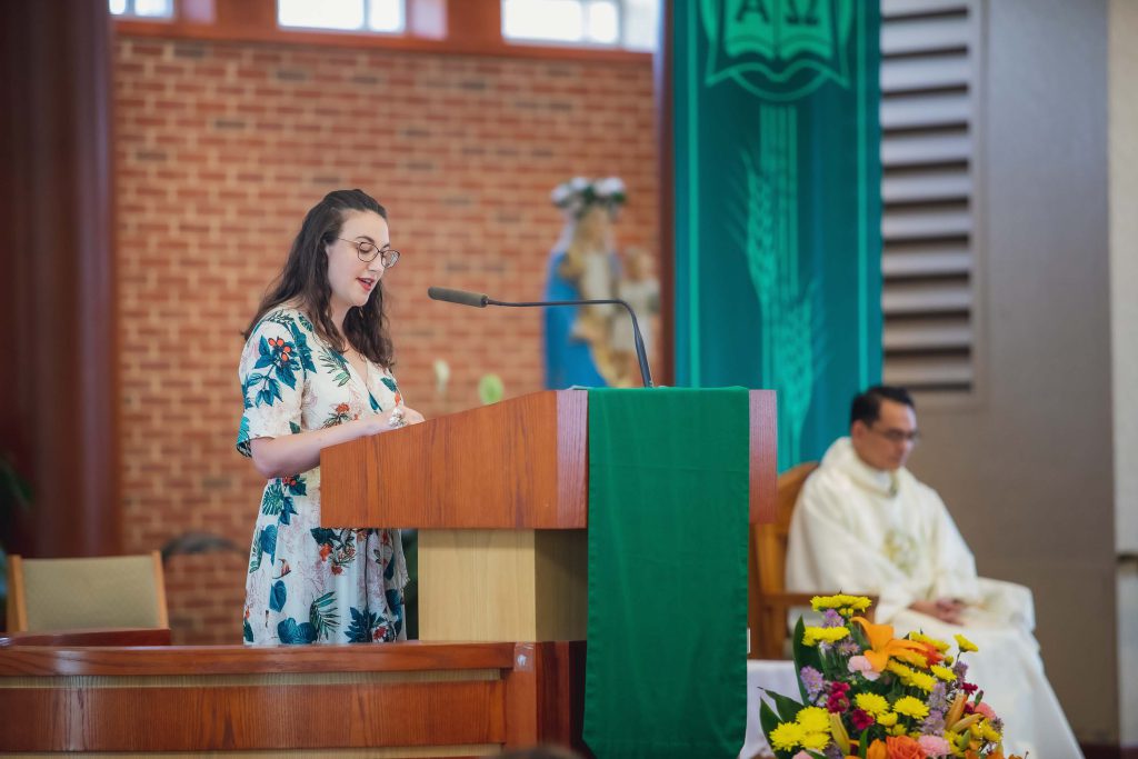 A woman standing at a podium during a wedding ceremony.