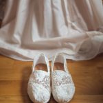A wedding shoes details on a wooden floor.