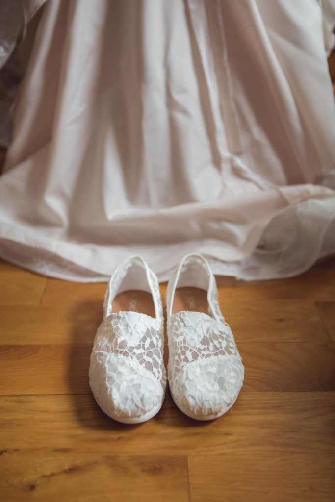 A wedding shoes details on a wooden floor.
