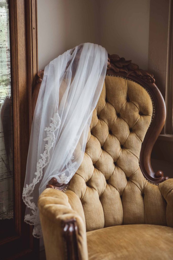 A wedding veil adorns a chair.