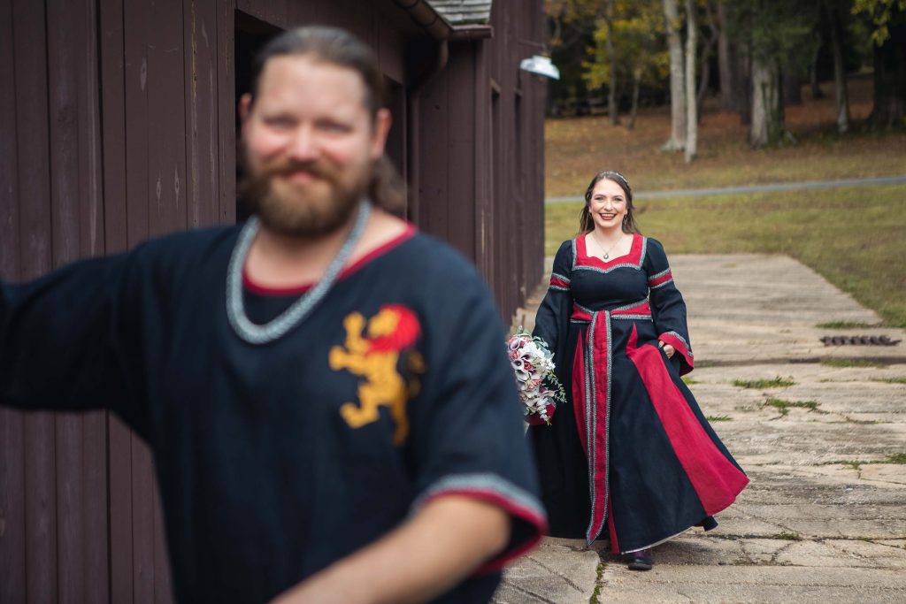 A man and woman dressed in medieval clothing are preparing for their candid wedding.