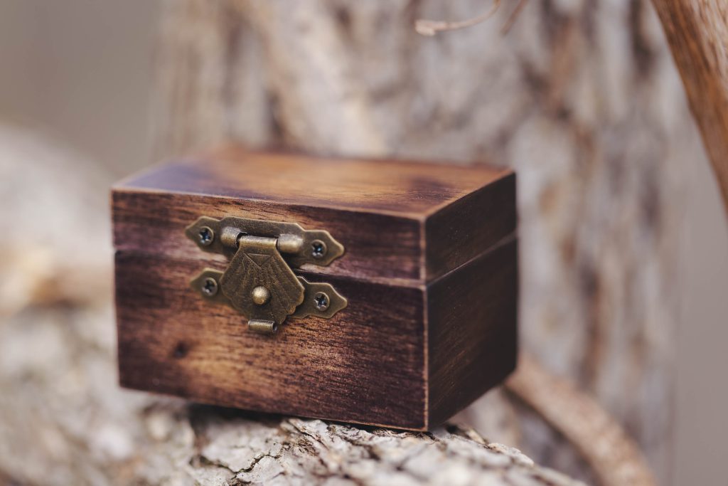 A small wooden box sitting on top of a tree branch with intricate details.