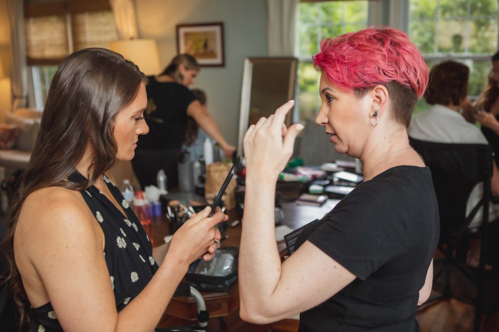 A woman is getting her makeup done before her wedding.