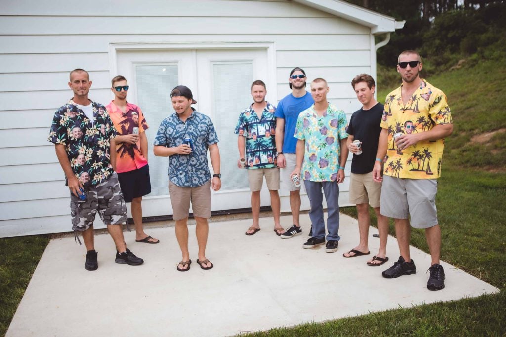 A candid group of men in Hawaiian shirts during wedding preparation.