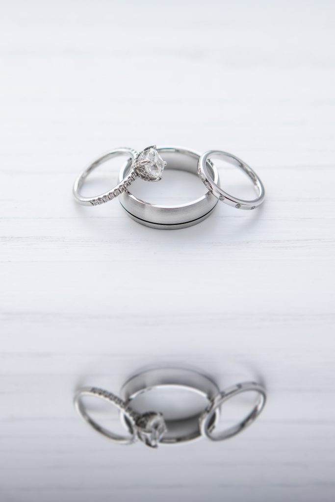 A detailed photograph of two wedding rings resting on a white surface.
