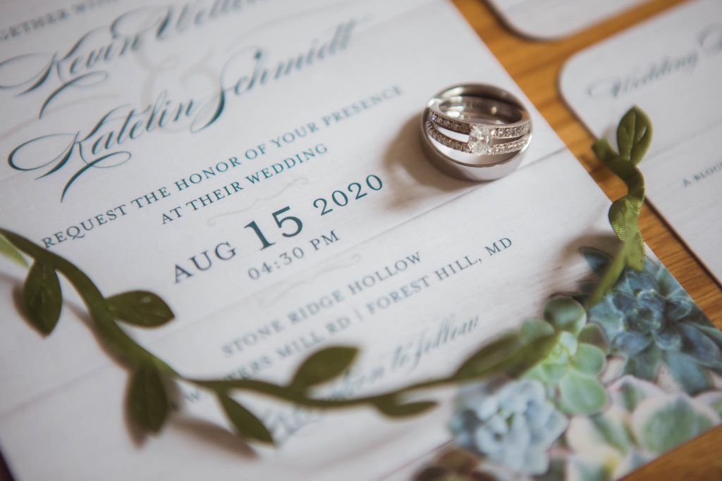 A wedding invitation adorned with a ring and succulents, showcasing intricate details.