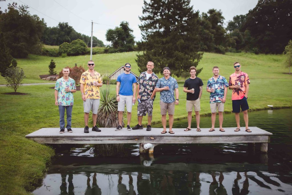 A group of men posing for a portrait on a dock.
