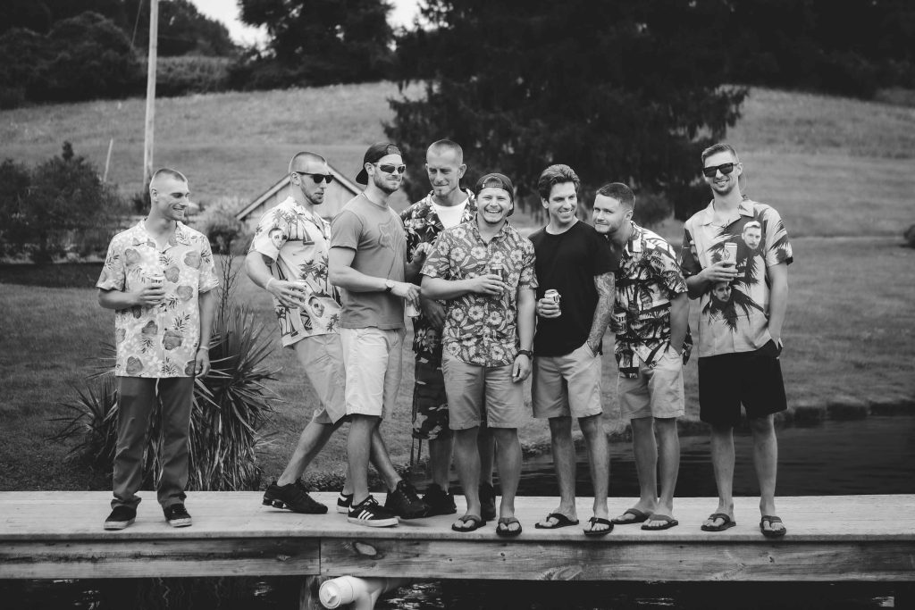 Black and white portrait of a group of men standing on a dock.