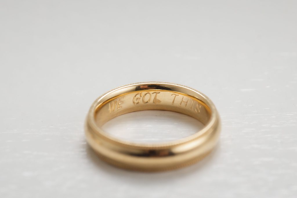 A detailed wedding ring with the word 'love' engraved on it.