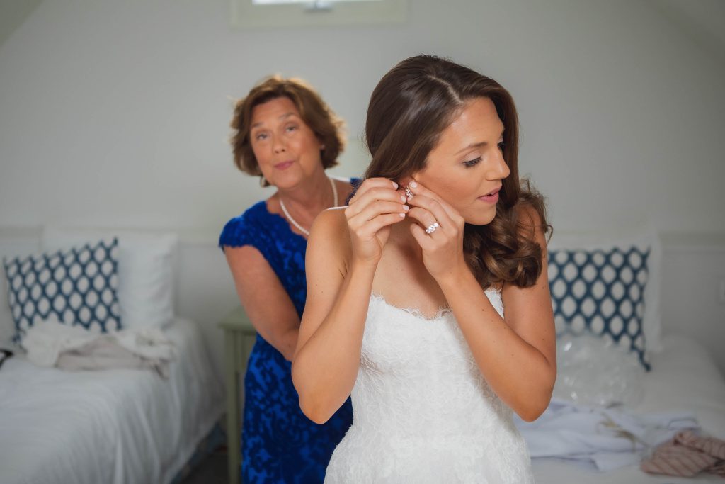 A candid bride assisting her mother during wedding preparations.