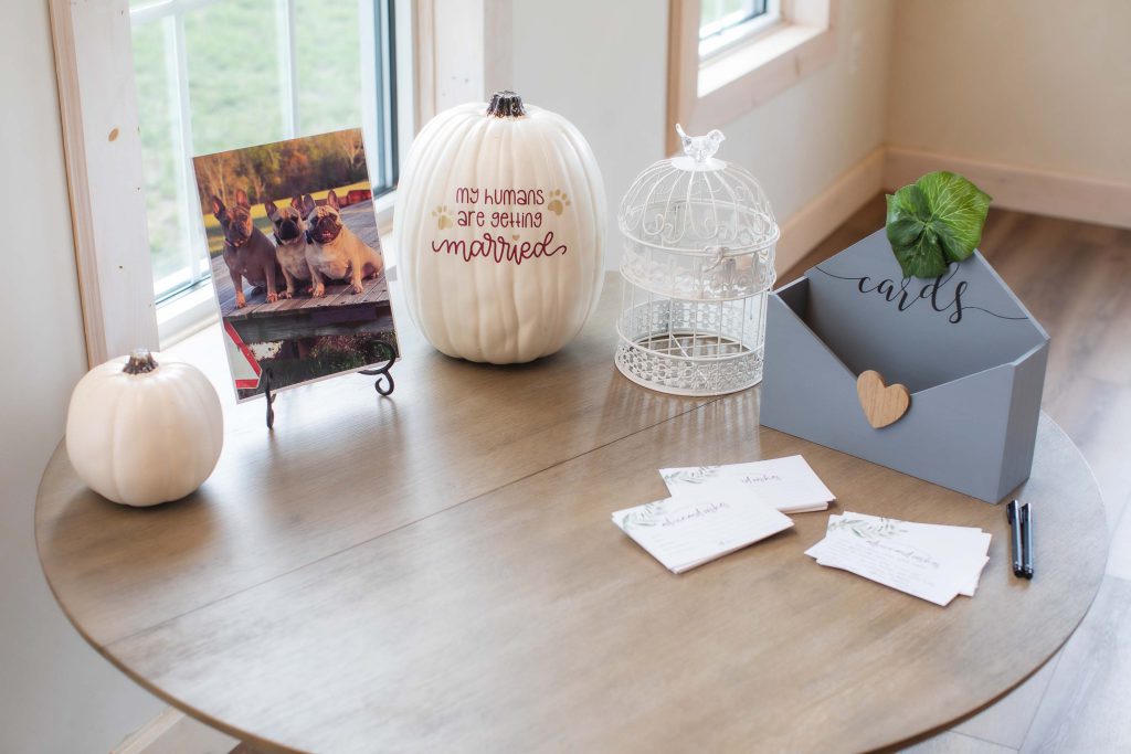 A wedding table with pumpkins and cards as decorative details.