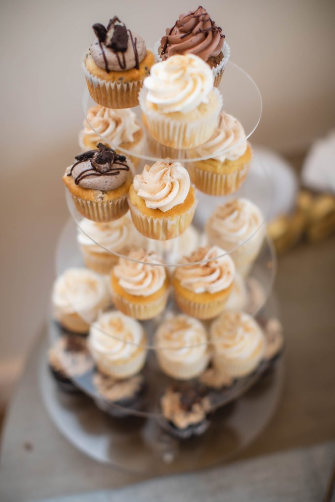 Wedding cupcakes displayed on a three-tiered stand.