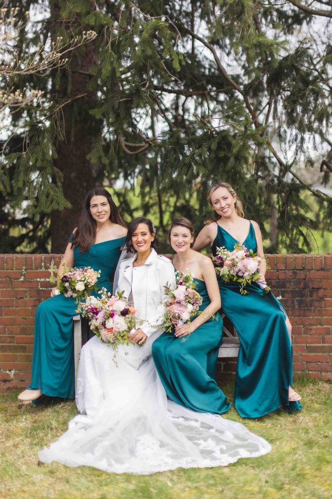 Four bridesmaids in teal dresses posing for a wedding portrait.