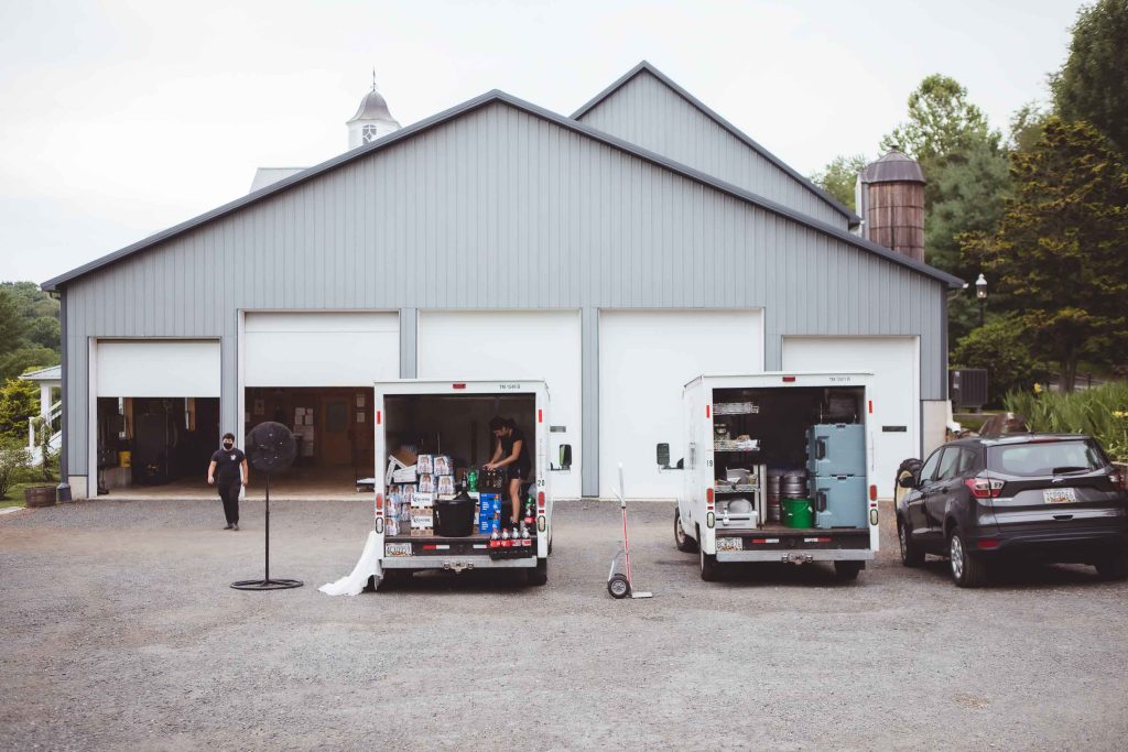 Two candid trucks parked in front of a barn.