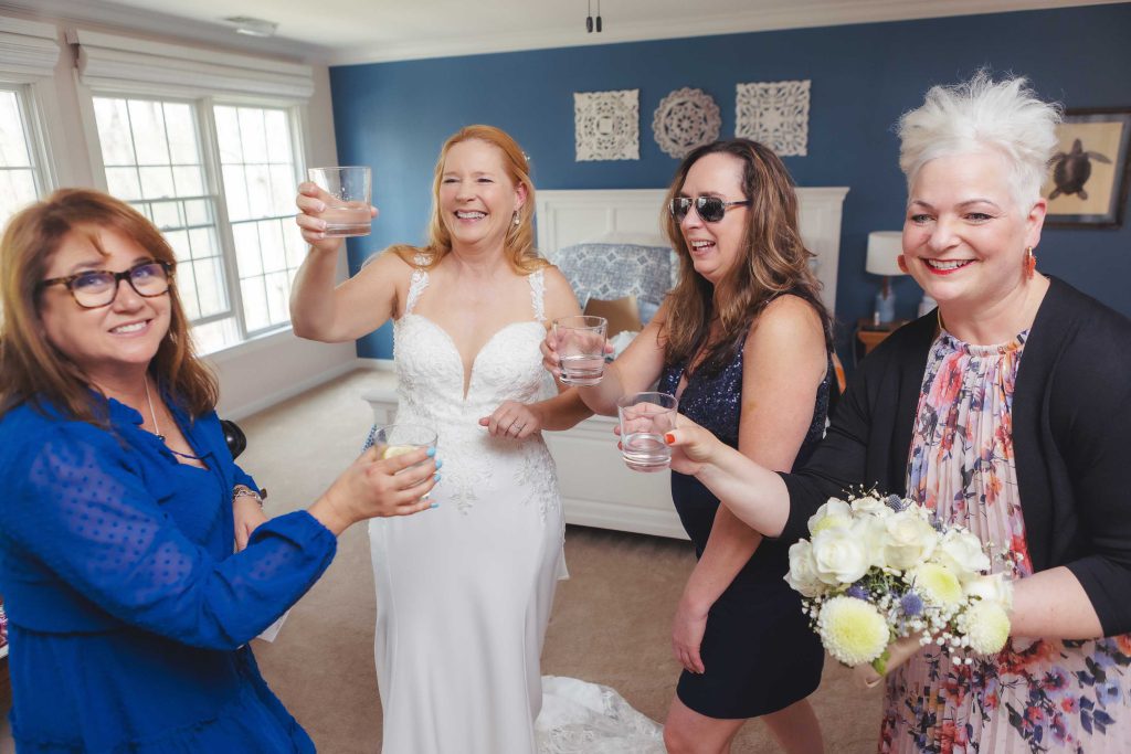A group of bridesmaids candidly toasting in preparation for the wedding.