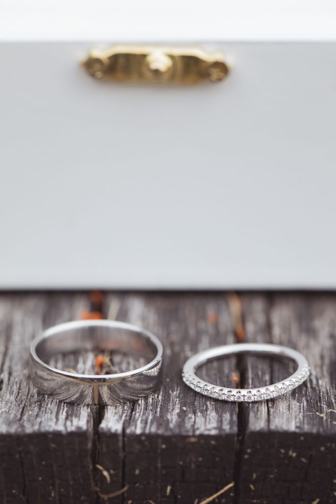 Wedding rings displayed on a wooden box emphasizing details.