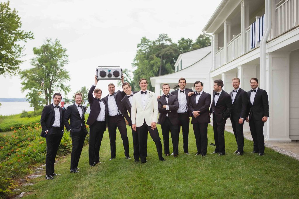 A group of groomsmen in tuxedos posing for a wedding portrait.